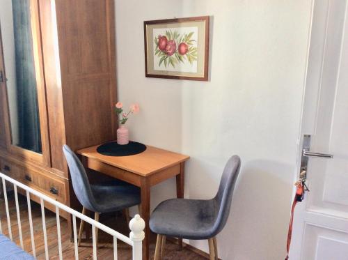 un tavolino con due sedie e un quadro di mele di Albergo Gargnano a Gargnano