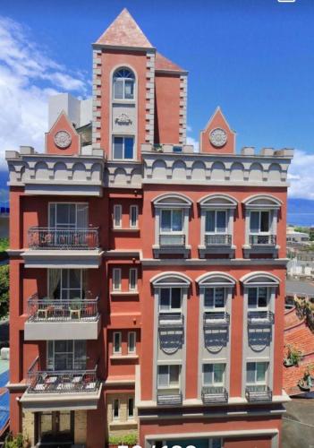 Un edificio alto con una torre de reloj en la parte superior. en 七星天使-七星潭電梯民宿, en Dahan