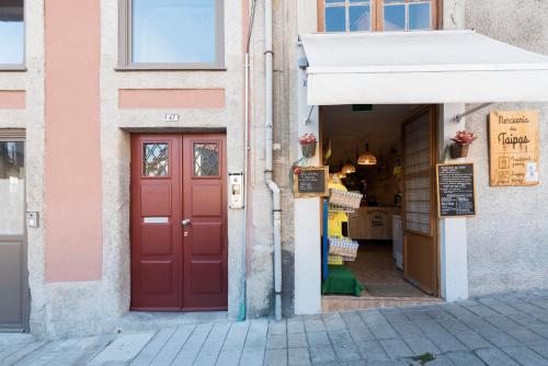 eine rote Tür in einem Gebäude mit einem Laden in der Unterkunft Tripas Coração Taipas Historical Center in Porto