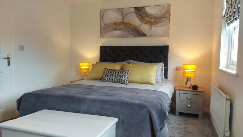una camera con un grande letto con due lampade di Waters Edge, Town house in Stourport-on-Severn a Stourport