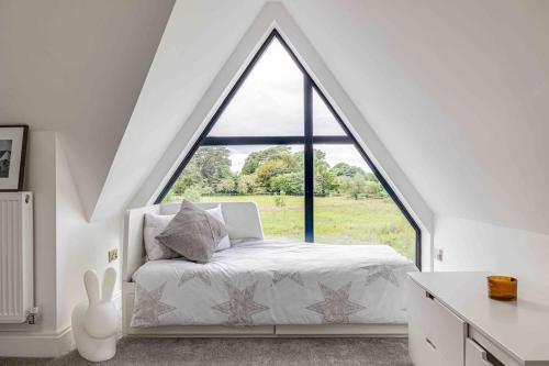 una camera da letto con un letto bianco e una grande finestra di 8986690/2023 a Birkenhead