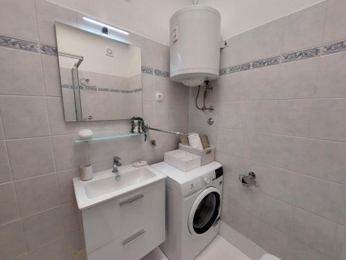 een badkamer met een wasmachine en een wastafel bij STEFAN 2 in Umag
