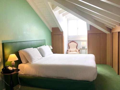 a bedroom with a white bed and a chair at Antica Locanda Leonardo in Milan