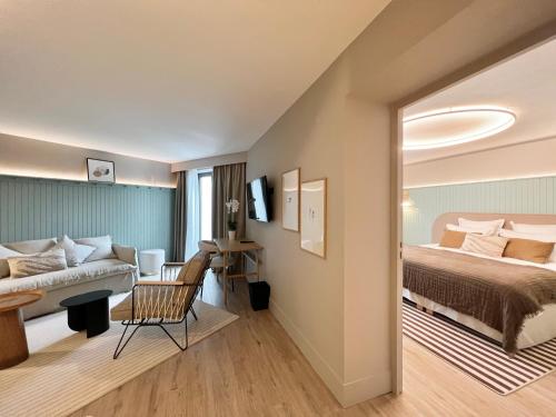 ディナールにあるEmeria Dinard Thalasso Spa - Avril 2024 Réouverture après rénovationのベッドとソファ付きのホテルルーム