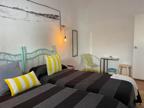 a bedroom with a bed with yellow and black pillows at PENSION SOCAIRE CONIL in Conil de la Frontera