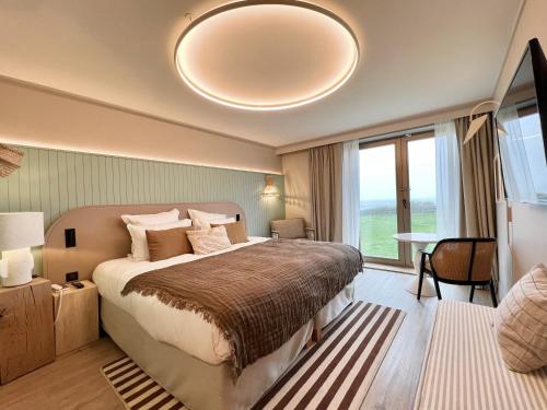 a bedroom with a large bed and a large window at Emeria Dinard Thalasso Spa in Dinard