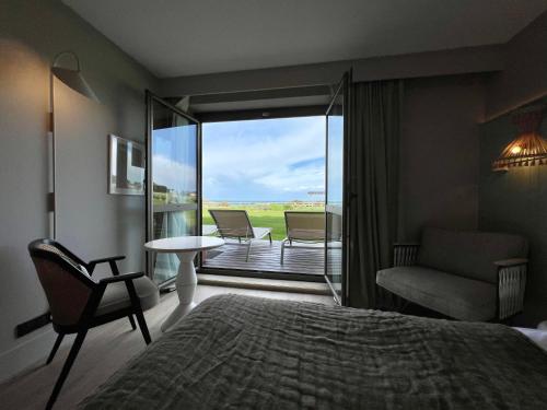 a bedroom with a bed and a view of a balcony at Emeria Dinard Thalasso Spa in Dinard