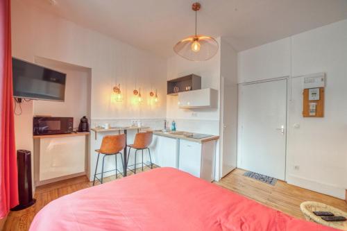 Cet appartement comprend une chambre avec un lit et une cuisine avec un bar. dans l'établissement La Casa Roja - Championnet / Caserne de Bonne, à Grenoble