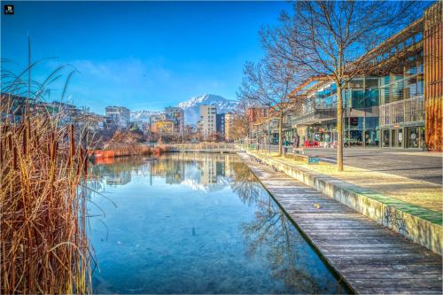 une vue d'une rivière dans une ville avec des bâtiments dans l'établissement La Casa Roja - Championnet / Caserne de Bonne, à Grenoble