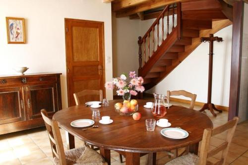 une table en bois avec des chaises et un escalier en bois dans l'établissement Le Gîte de Cals Haut, à Lacombe