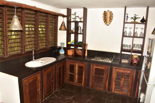 uma casa de banho com um lavatório e armários de madeira em LOCAVACATION Les Hauts Manguiers Villa 2 em Nosy Be
