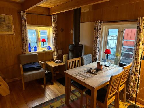 a dining room with a table and a stove at Handkleppveien 26 - Fishermans cabin in Straume