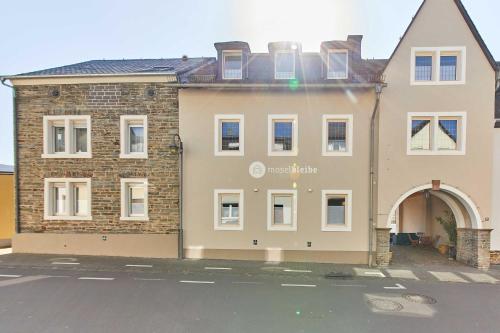 a large brick building with an archway in a parking lot at NEU!!! Moselbleibe Winzerhaus Kues in Bernkastel-Kues