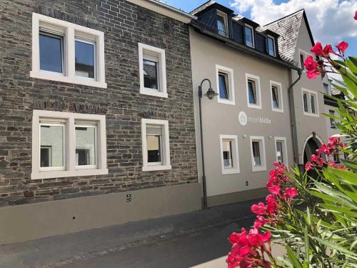 a brick building with white windows and pink flowers at NEU!!! Moselbleibe Winzerhaus Kues in Bernkastel-Kues