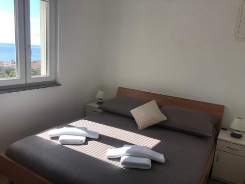 ein Schlafzimmer mit einem Bett mit zwei Handtüchern darauf in der Unterkunft Apartmani Ivana in Cres