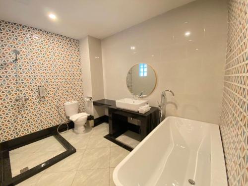 a bathroom with a tub and a toilet and a sink at Manomon residence มโนมน เรสซิเดนซ์ in Khon Kaen
