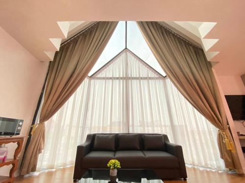 a couch sitting in front of a large window at Manomon residence มโนมน เรสซิเดนซ์ in Khon Kaen