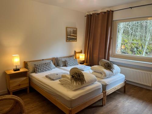 um quarto com 2 camas com almofadas e uma janela em Rivendell I3 em Monschau