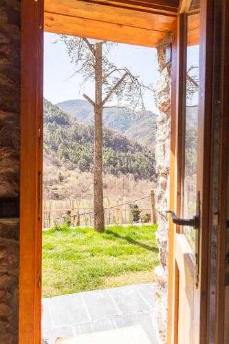 an open door with a view of a mountain view at Casa rústica la Borda de la Munda. in Arsèguel