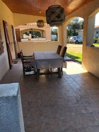 une terrasse avec une table et des chaises dans une maison dans l'établissement Villa en corse du sud entre mer et montagne, à Peri