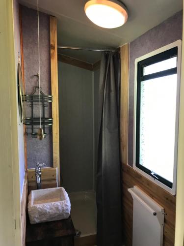 bagno con vasca, lavandino e finestra di The Vobster Inn a Radstock