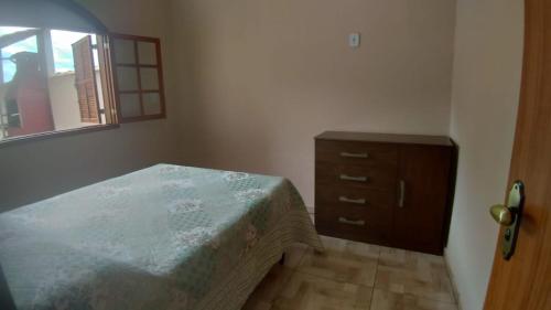 1 dormitorio con 1 cama, vestidor y ventana en hospedagem recanto do sábia 3 en Caparaó Velho