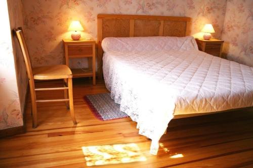 - une chambre avec un lit, une chaise et deux lampes dans l'établissement Le Gîte de Cals Haut, à Lacombe