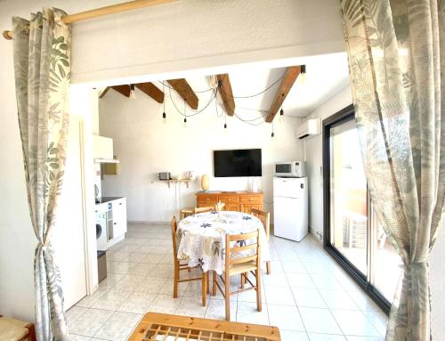 une cuisine et une salle à manger avec une table et des chaises dans l'établissement Appartement charmant à Saint-Cyprien Plage - 34 m² + Terrasse, à Saint Cyprien Plage