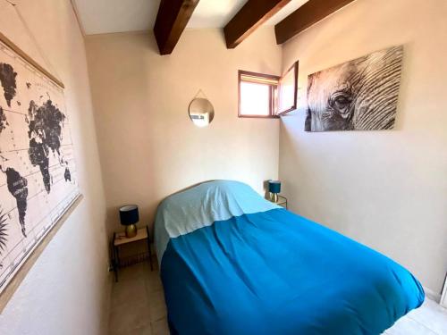 um quarto com uma cama azul num quarto em Appartement d'une chambre a Saint Cyprien Plage a 150 m de la plage avec terrasse et wifi em Saint-Cyprien-Plage