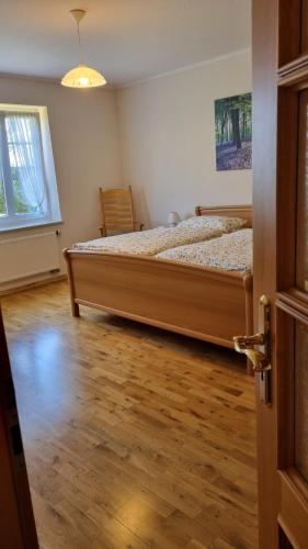 a bedroom with a bed and a wooden floor at Ferienwohnung an der Mühle in Bad Zwischenahn