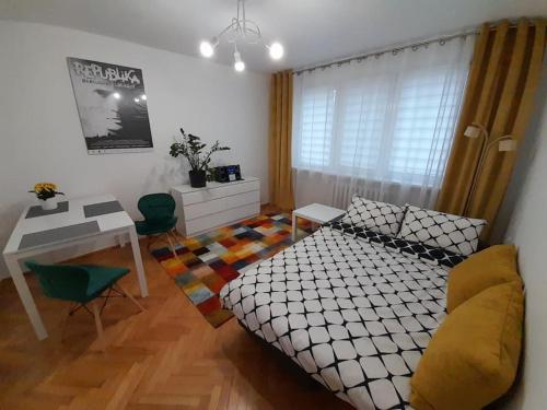 een slaapkamer met een bed, een tafel en een bureau bij Kinga in Toruń