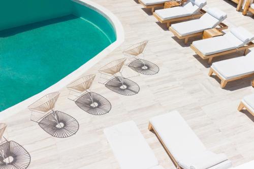 an overhead view of lounge chairs and a pool at Cavo Bianco Boutique Hotel & Spa in Kamari