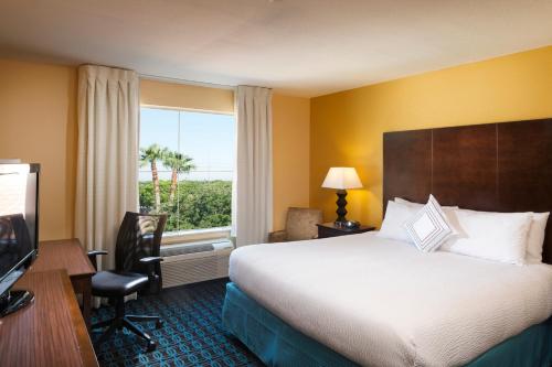 a hotel room with a large bed and a window at Fairfield Inn & Suites Houston Intercontinental Airport in Houston