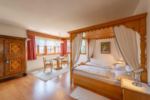 a bedroom with a canopy bed and a table at Haus Bellutti in Termeno