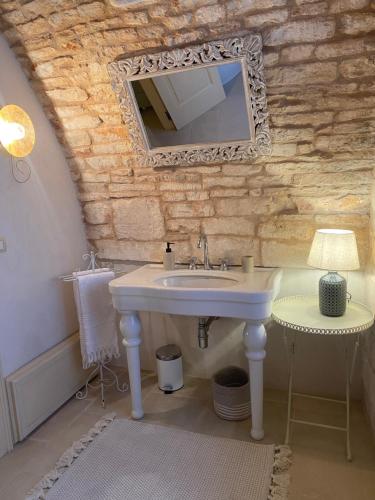 a bathroom with a sink and a mirror at PalazzOliva - Boho chic Guest house in the historic heart of Martina Franca in Martina Franca