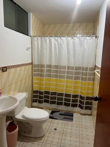 y baño pequeño con aseo y ducha. en Departamento Amplio Pérez Gamboa, en Tacna