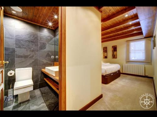 y baño con cama, lavabo y ducha. en BACIVER de Alma de Nieve, en Naut Aran (Alto Arán)
