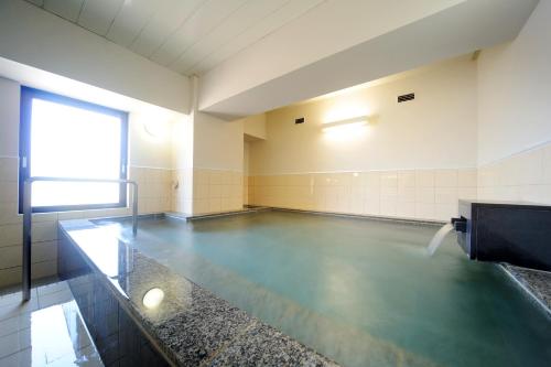 a gymnasium with a pool of water in a room at Smile Hotel Yonezawa in Yonezawa