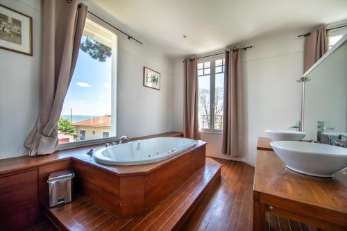 a large bathroom with two sinks and a tub at Villa Les Délices in Cap-Ferret