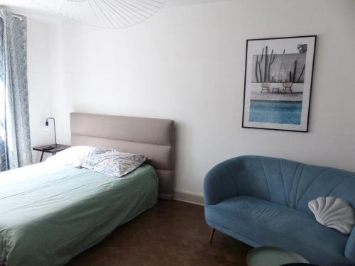 een slaapkamer met een bed en een blauwe stoel bij Bagatelle - 2 chambres in Talence