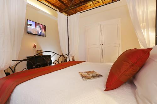 a bedroom with a bed with red pillows and a television at Madonna de' Monti Suites in Rome