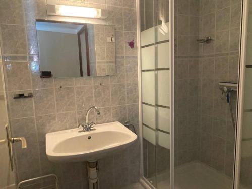 une salle de bain avec un lavabo et une douche avec un miroir dans l'établissement Maison 2 pièces avec mezzanine, terrasse et parking - Proche plage, Argelès-sur-Mer - FR-1-225-682, à Argelès-sur-Mer