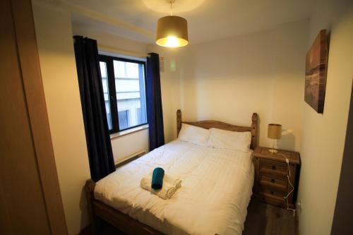 a small bedroom with a bed and a window at Seaside Views in Galway