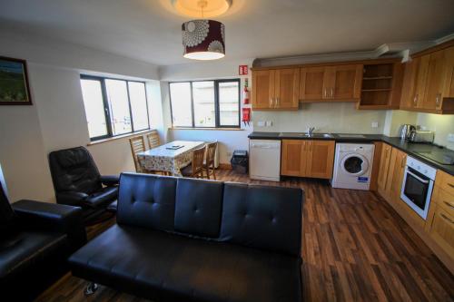 a living room with a couch and a kitchen at Seaside Views in Galway