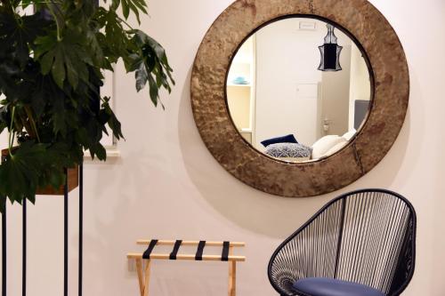 a mirror hanging on a wall next to a chair at B&B Dimora Vistamare in Barletta