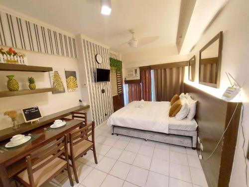 a bedroom with a bed and a desk in a room at Cityland Prime Residences by KF in Tagaytay
