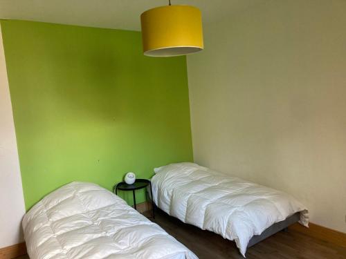 two beds in a room with a green wall at Appartement Brides-les-Bains, 3 pièces, 4 personnes - FR-1-512-267 in Brides-les-Bains