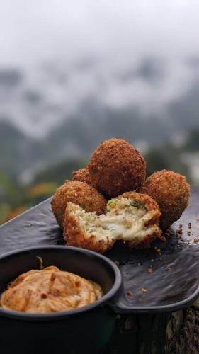 a black plate with some food on a table at Wild Himalaya Glamping Camp in Nārkanda