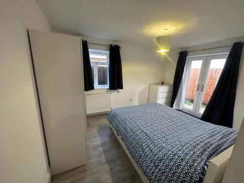 um quarto com uma cama e uma grande janela em 2 Bedroom house,BrownhillRd SE6 em Londres