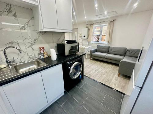 a kitchen with a sink and a washing machine at 2 Bedroom house,BrownhillRd SE6 in London
